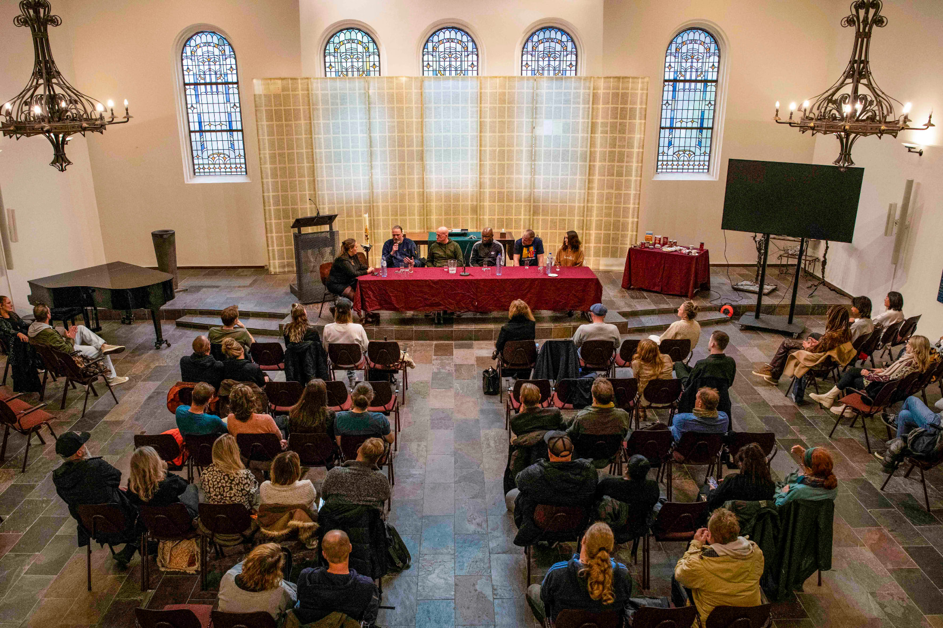 Wide view of the pilot panel at Oranjekerk with audience seated in the church hall