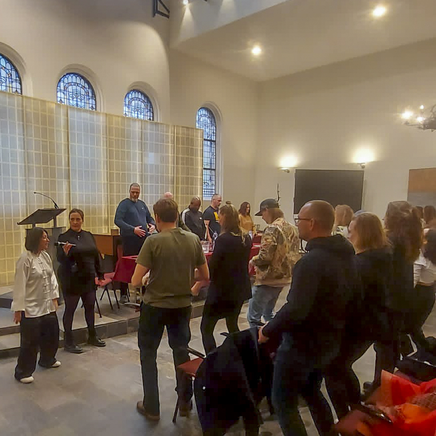 Participants joining a standing wellness practice in the Oranjekerk hall