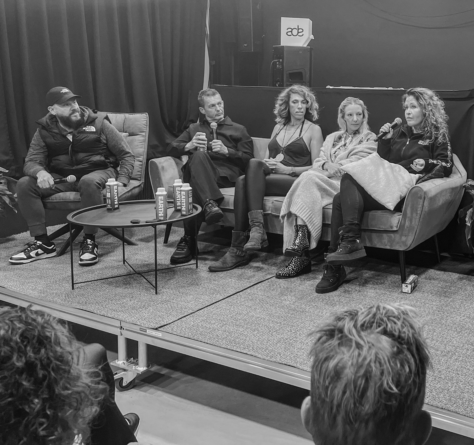 Black and white view of the panelists on stage during the 2023 edition