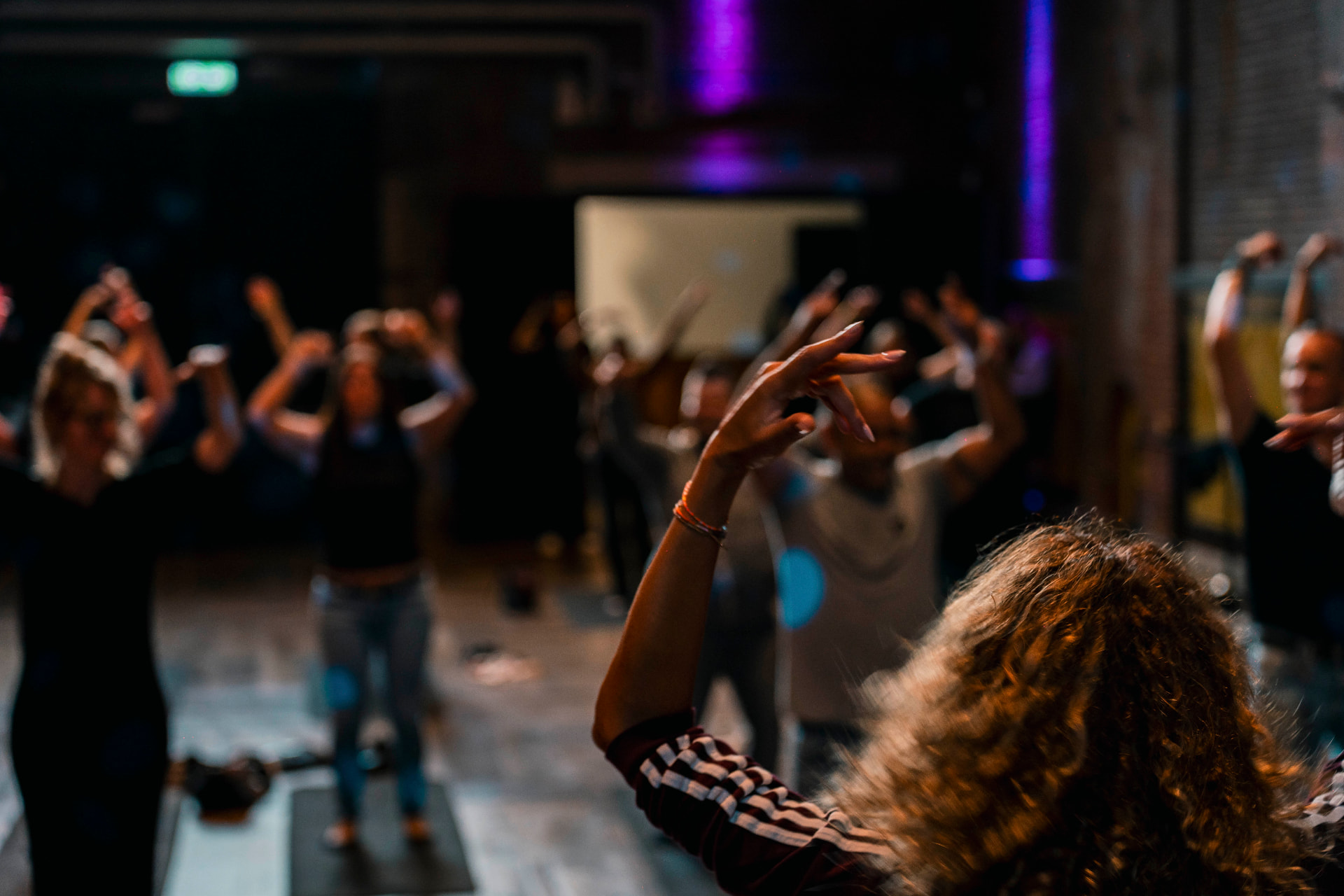 Participants with raised arms during a techno yoga session