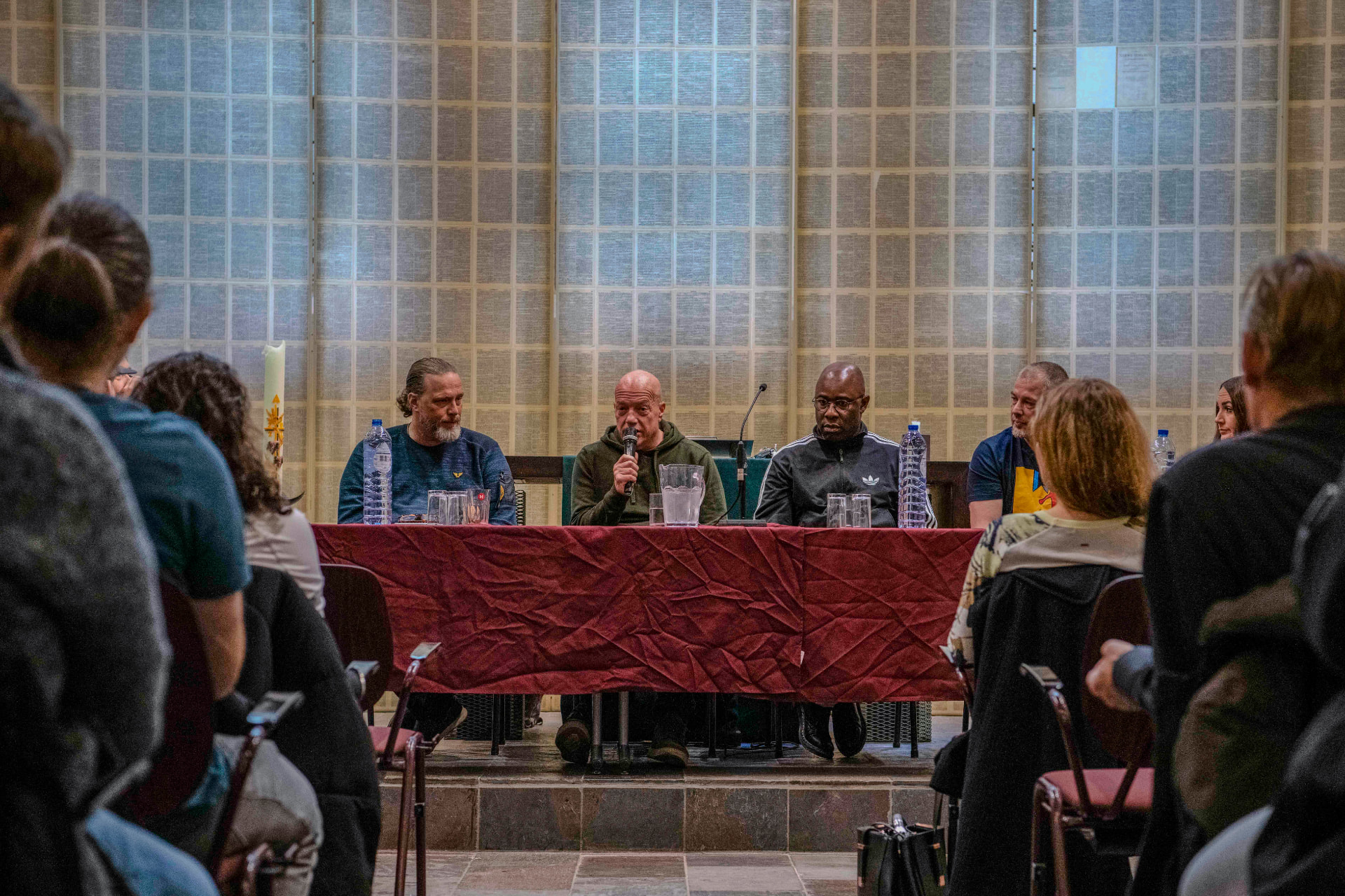 Panelists speaking into a microphone at the 2022 round table talk at Oranjekerk