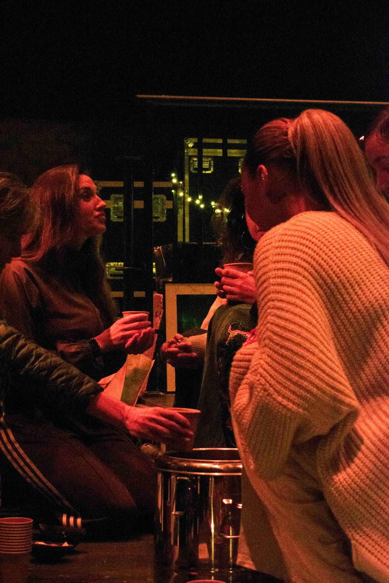 Attendees talking over cups of cacao in warm orange light