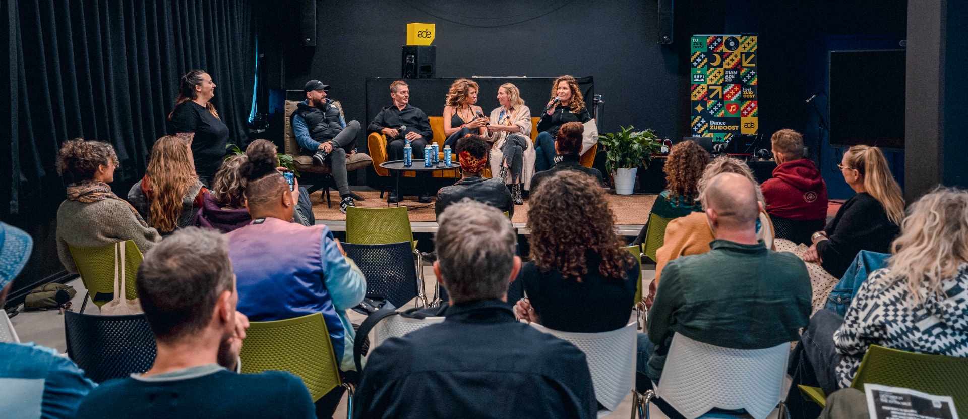 Wide view of the panel conversation with the audience seated in front of the stage