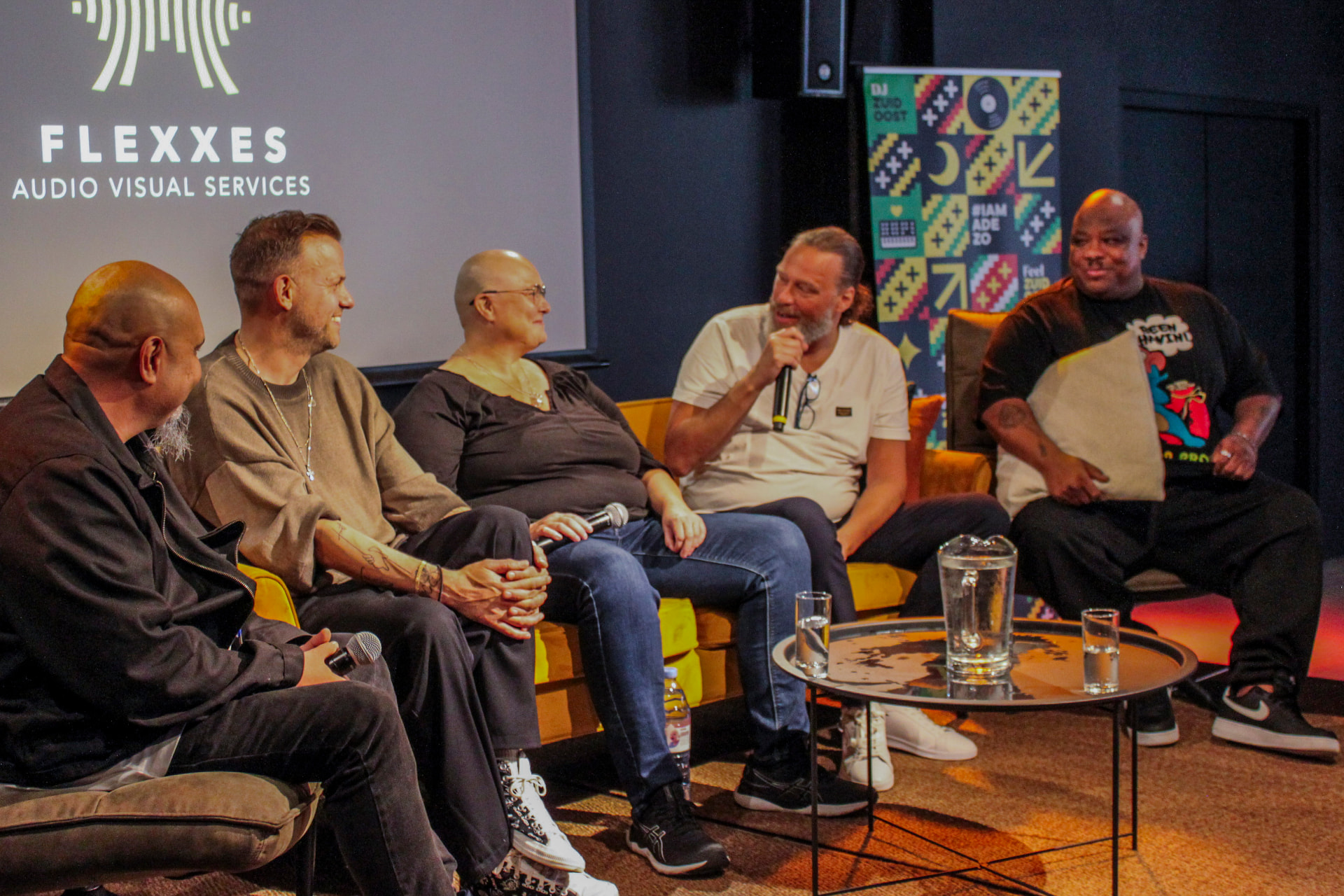 Five panelists seated together on stage during the 2023 panel discussion