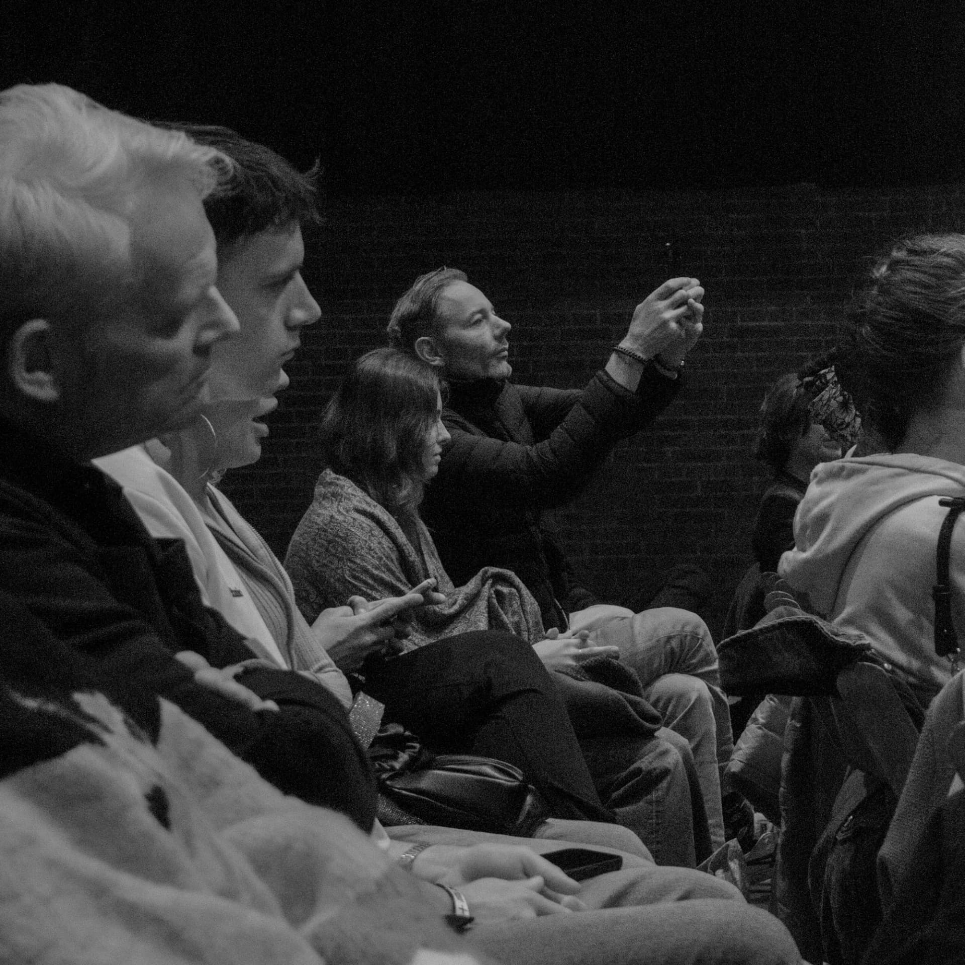 Attendees seated in a circle listening during a group conversation