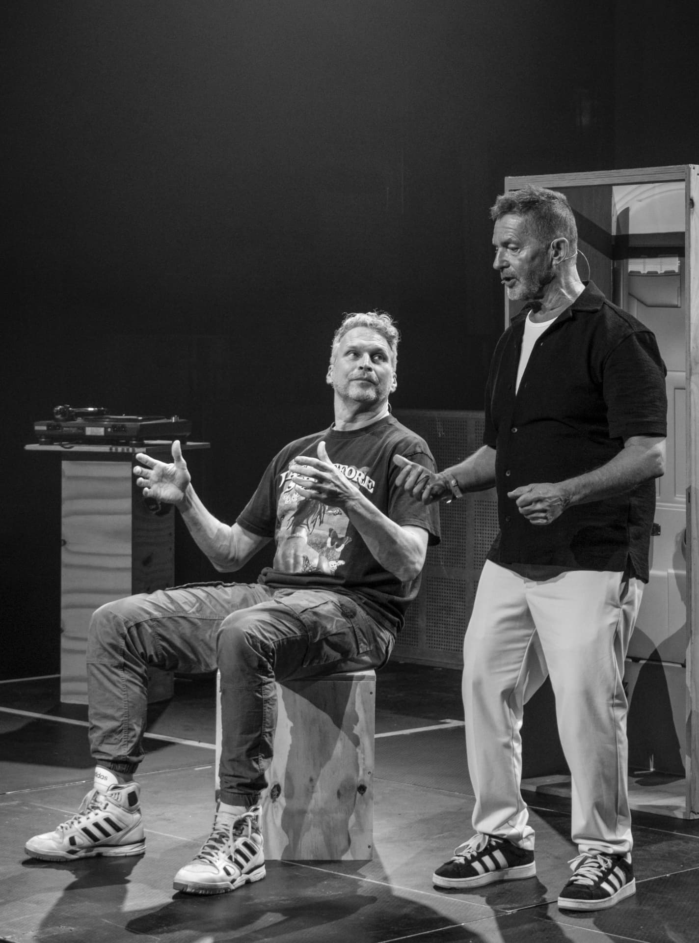 Nightlife voor Dummies theatre performance with Ronald Molendijk seated and Mick Boskamp standing beside him