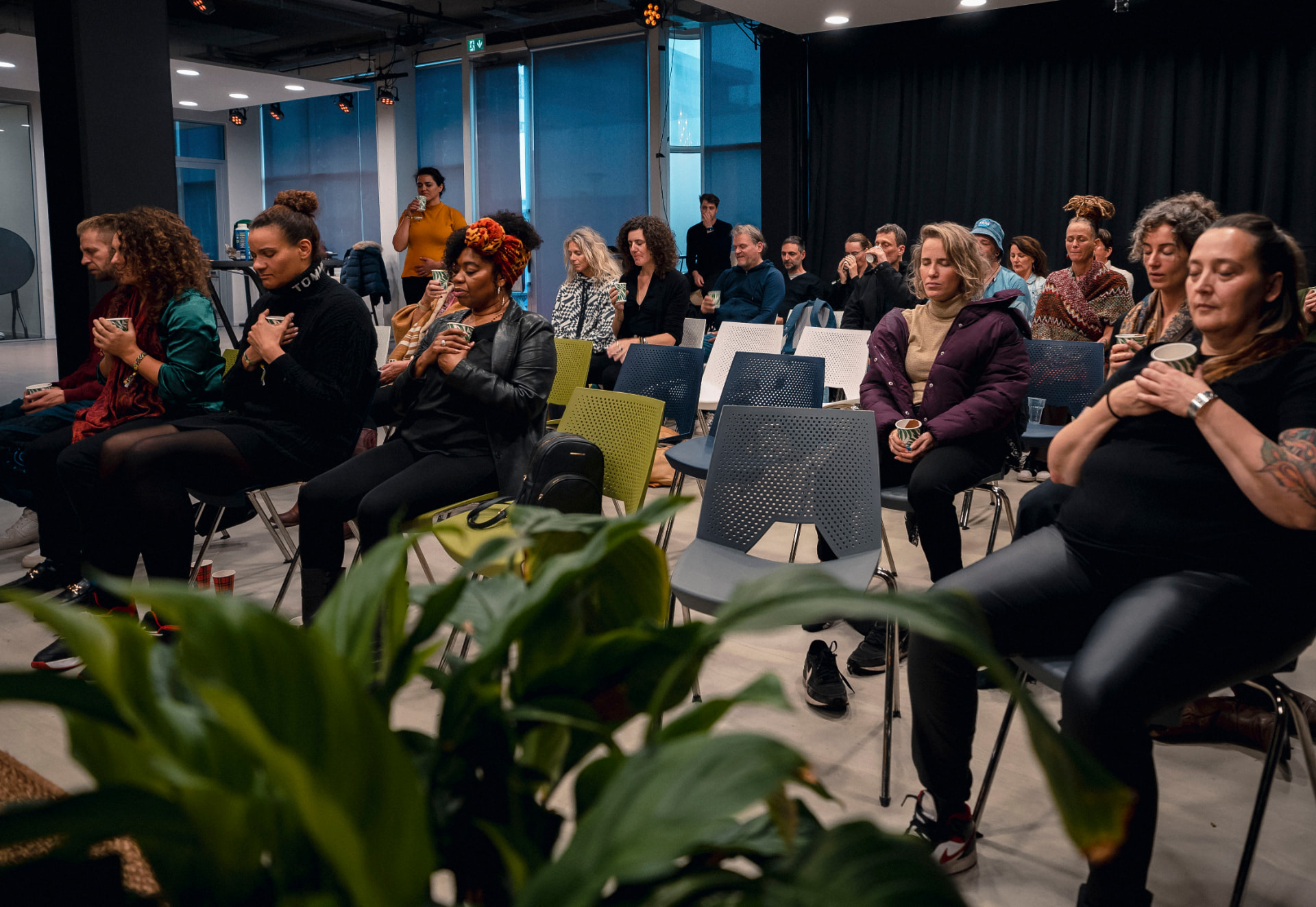 Audience members holding cups during a wellness session at the 2023 edition